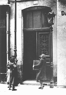 A Jewish women carries her radio into a police station after a German order (August 8, 1941) 
demanded the confiscation of all radios owned by Jews. 
Paris, France, 1941.